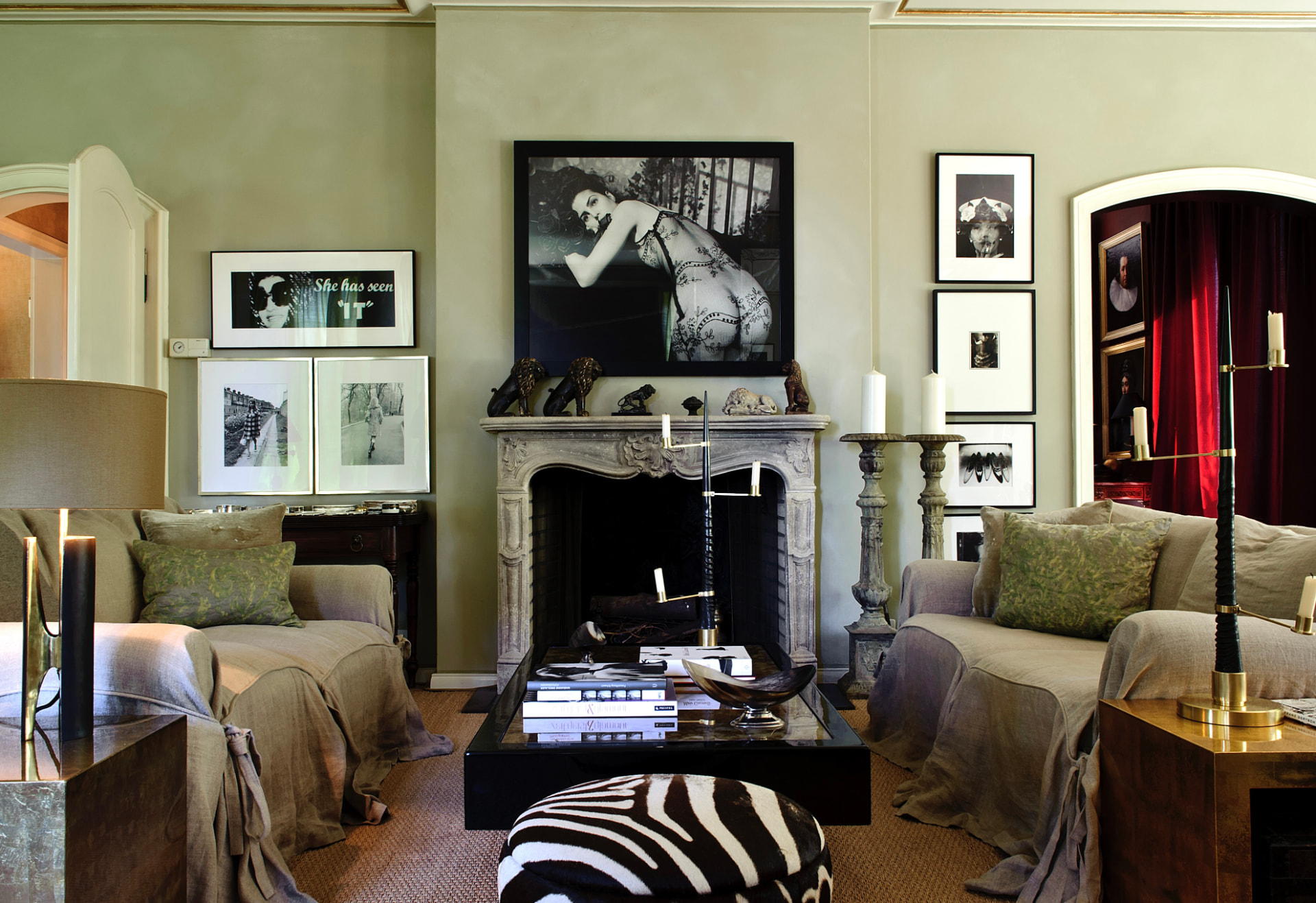 Collector's salon with framed black and white photographs above a stone fireplace