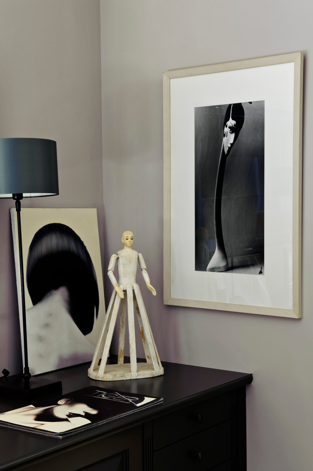 Corner of a collector's room with a framed black and white photograph, painting and sculpture